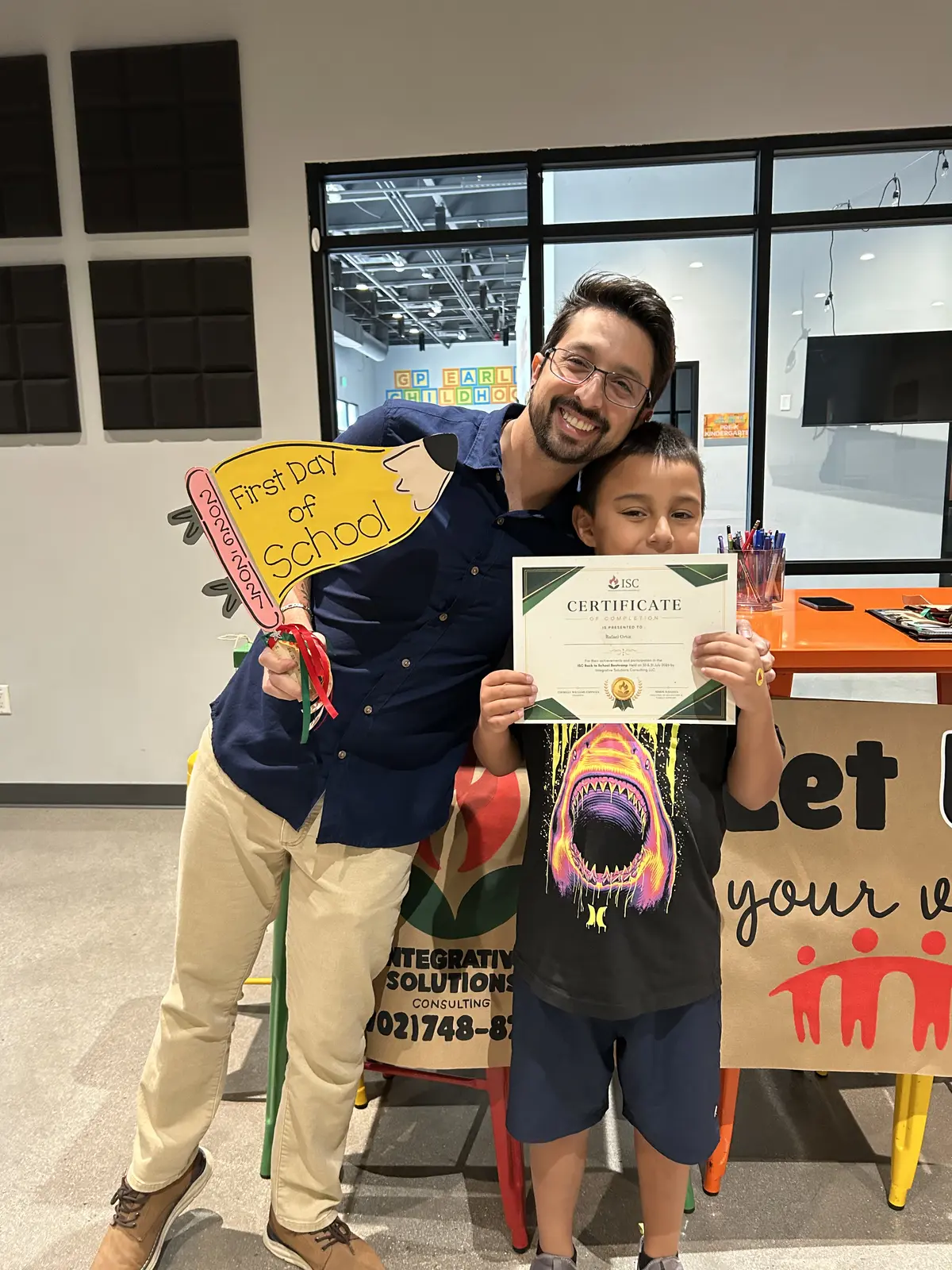 An ISC student holding a certificate with an educator on the first day of school