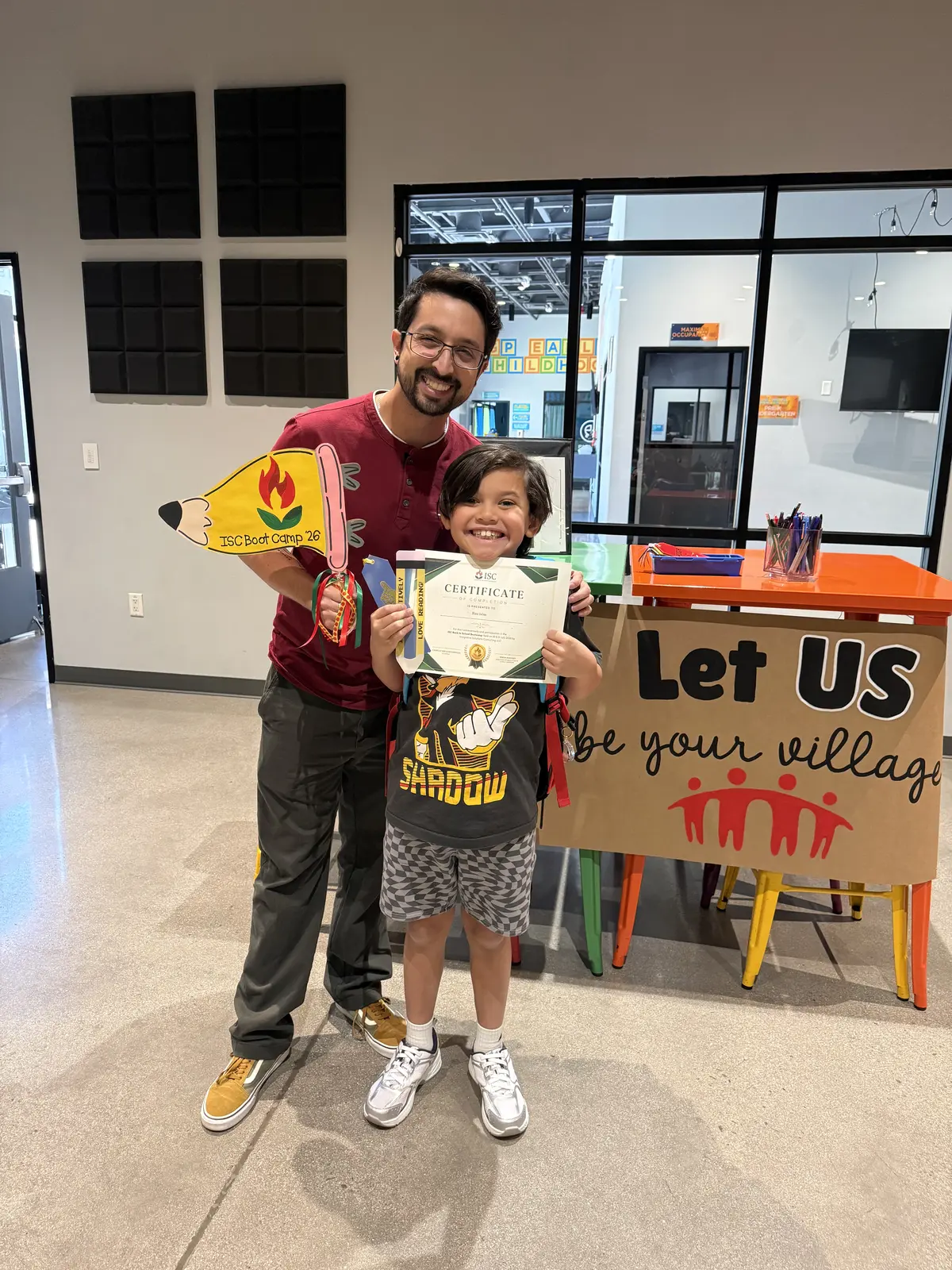 An ISC student holding a certificate with an educator after completing boot camp